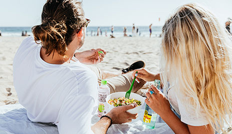 photo of man and woman enjoying Tocaya food at the beach