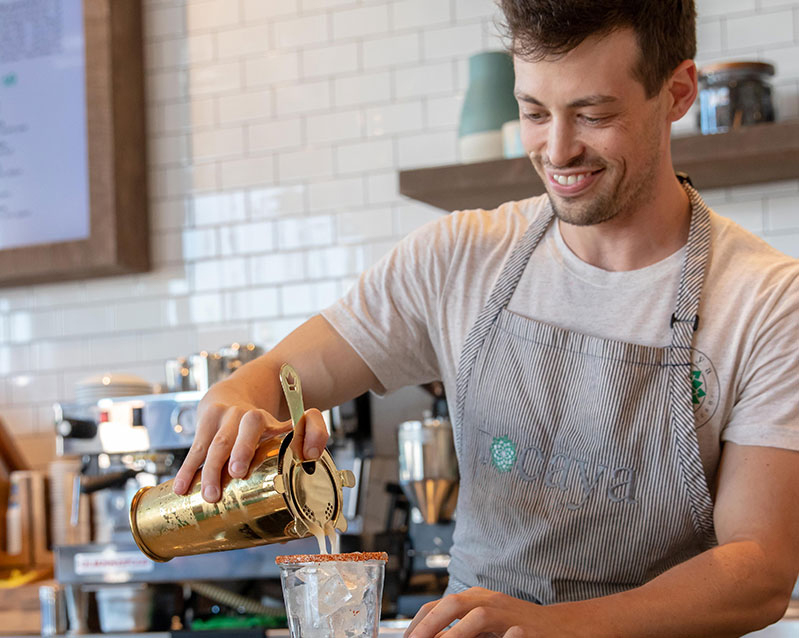 photo of Tocaya bartender smiling while pouring a mixed drink