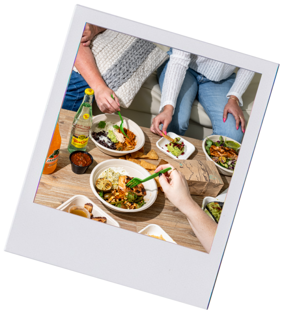 photo of people's hands serving themselves food from a table